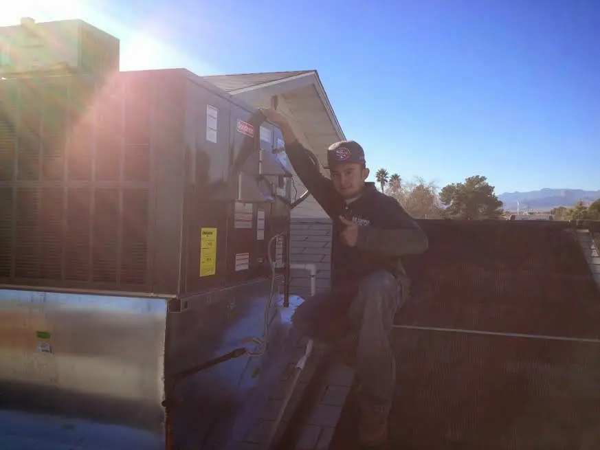HVAC technician performing Heat Pump Repair on a rooftop unit in Southport